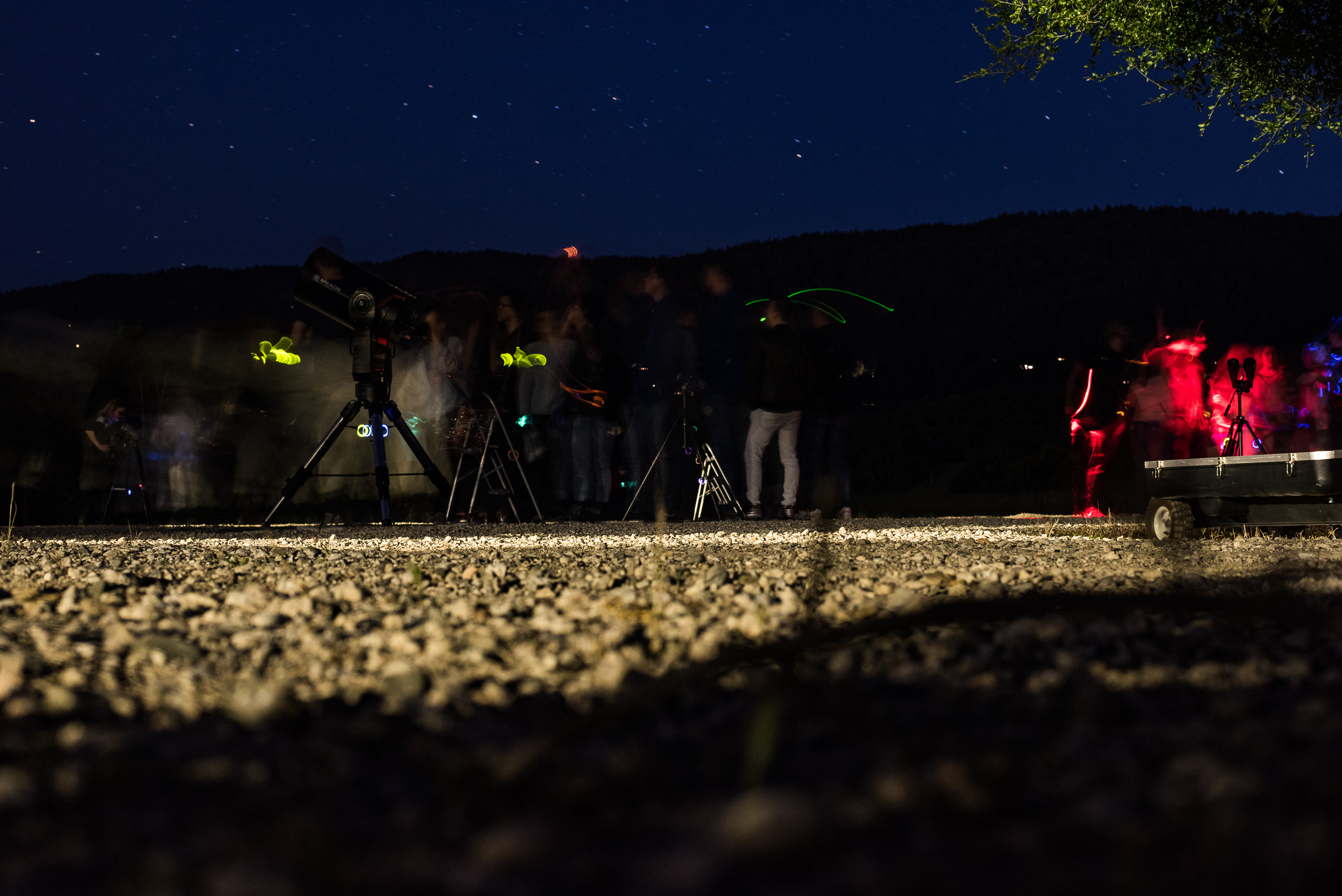 Star party guests celebrating around the telescopes with light sticks