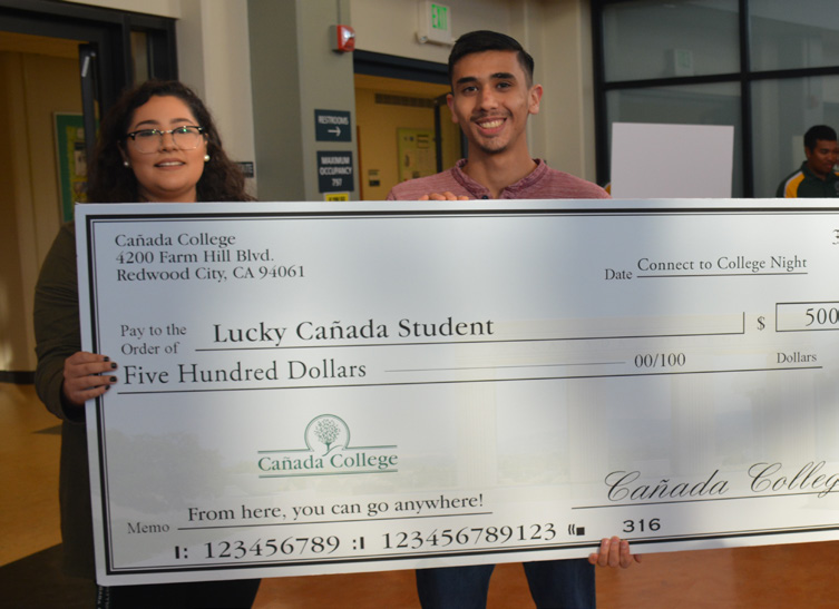 student holding $500 check