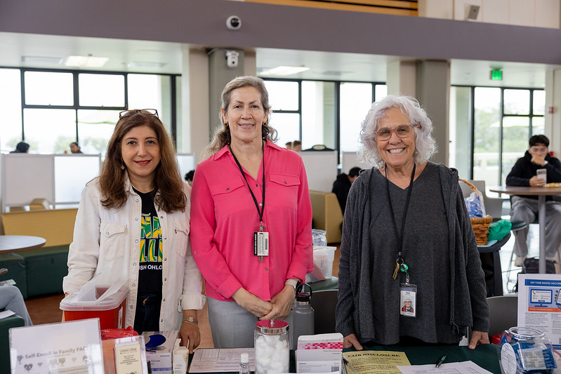 Health Center staff smiling at the camera while tabling for the Health & Wellness Fair