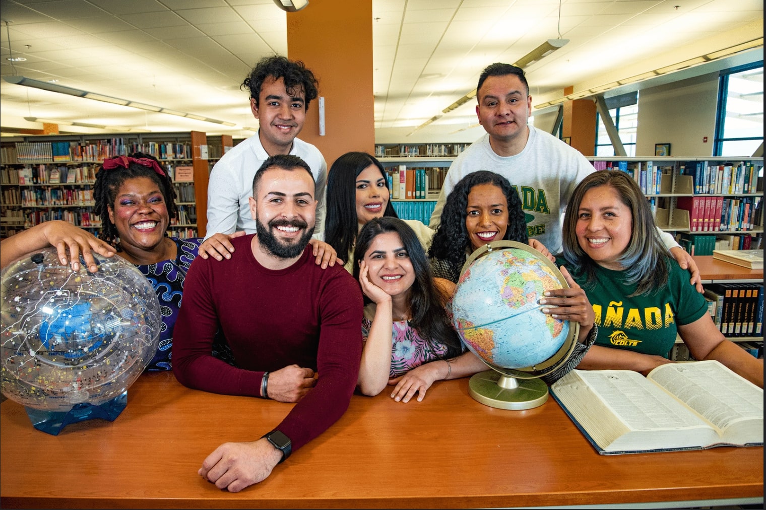 A group of students posing for a picture in the library