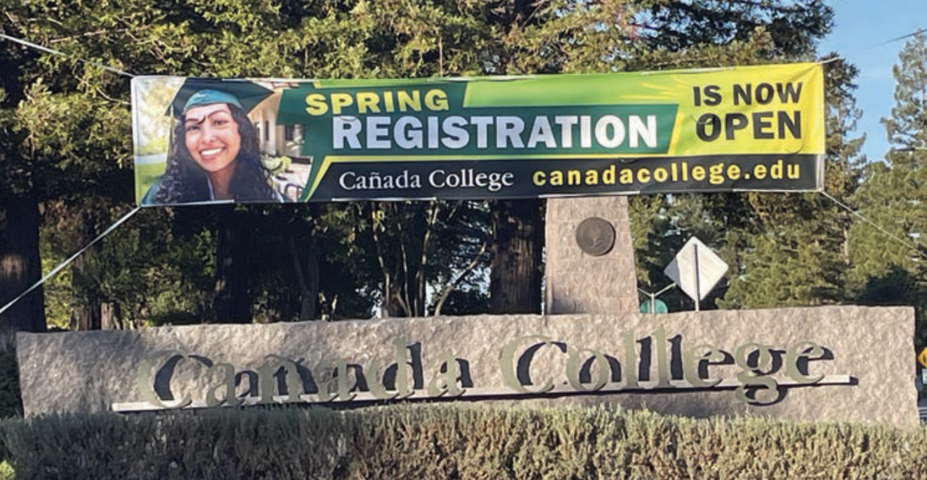 Cañada College stone entrance sign with a spring registration banner