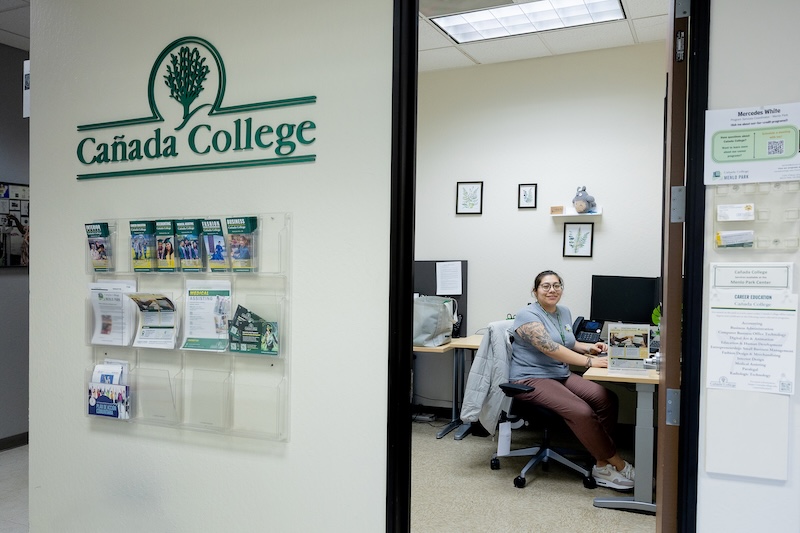 Outreach staff member sitting at a desk in an office at the Menlo Park site