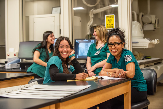Group of Cañada College health science students in scrubs working in a lab